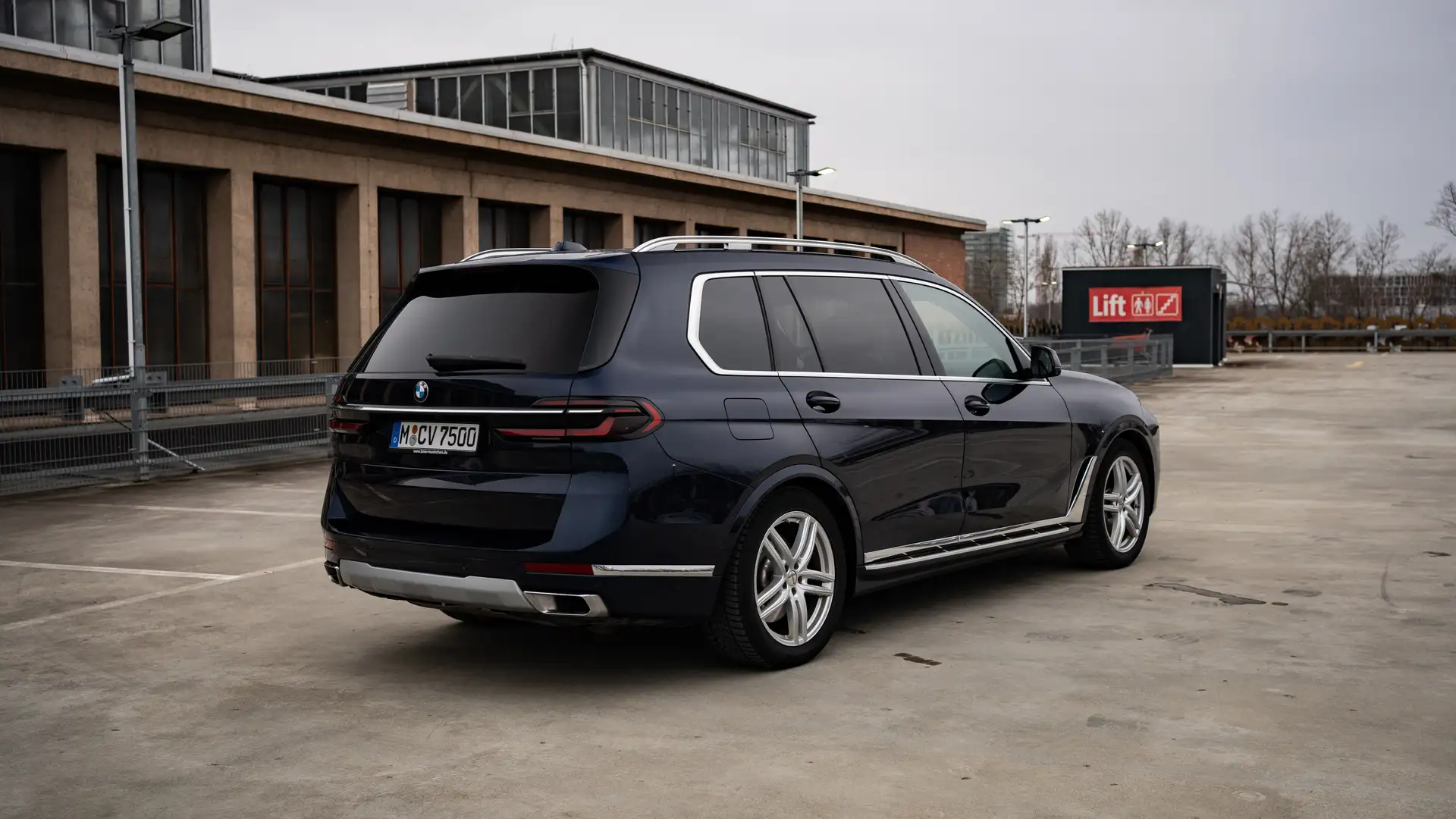 Our BMW X7 in Dark Blue in the side rear view.